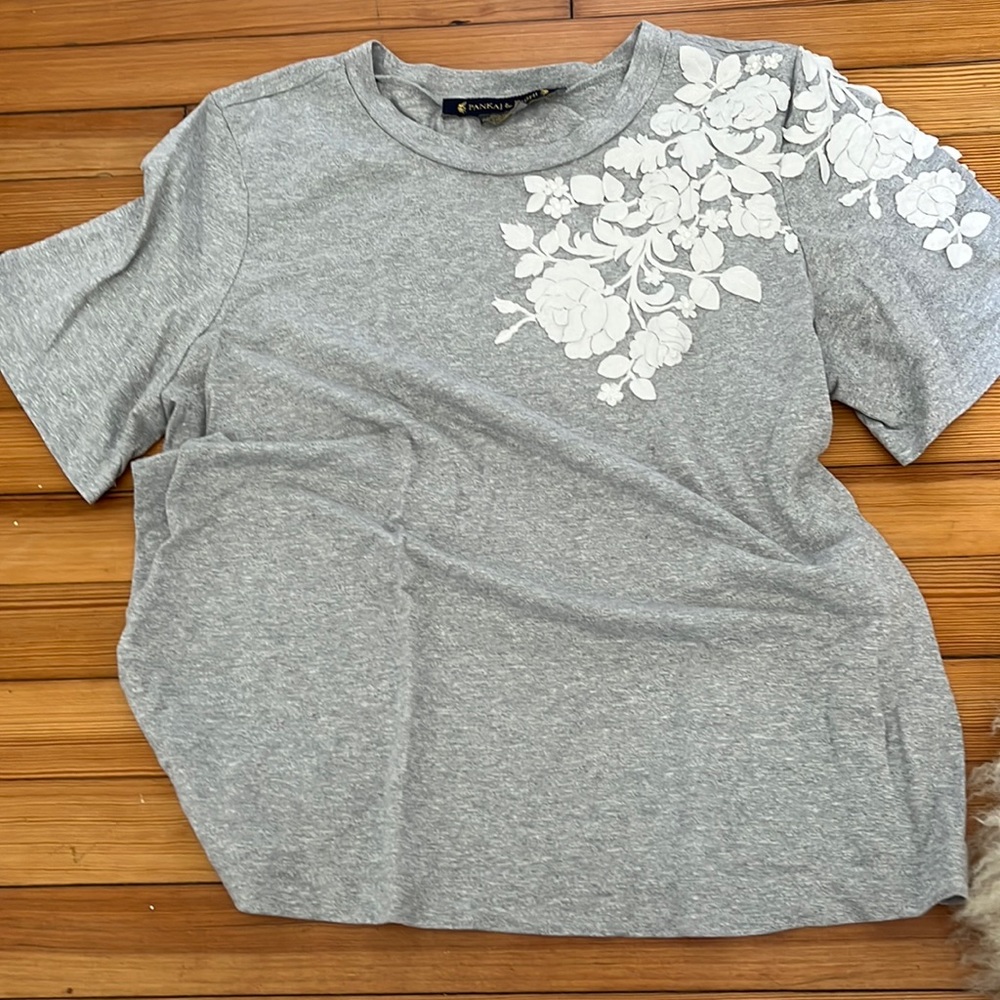 light grey t-shirt with white flowers on the shoulder